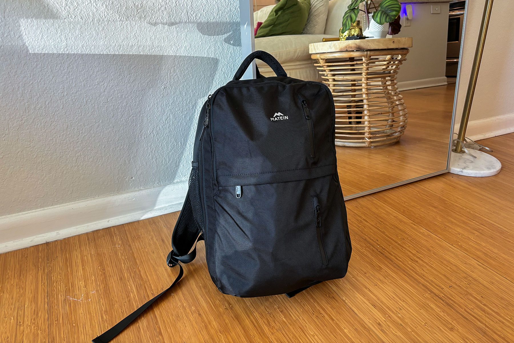 A black backpack on a wood floor