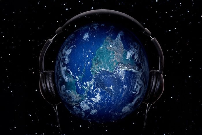 Planet Earth In Headphones on starry sky background