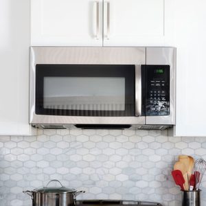 Microwave in a modern kitchen with white cabinets